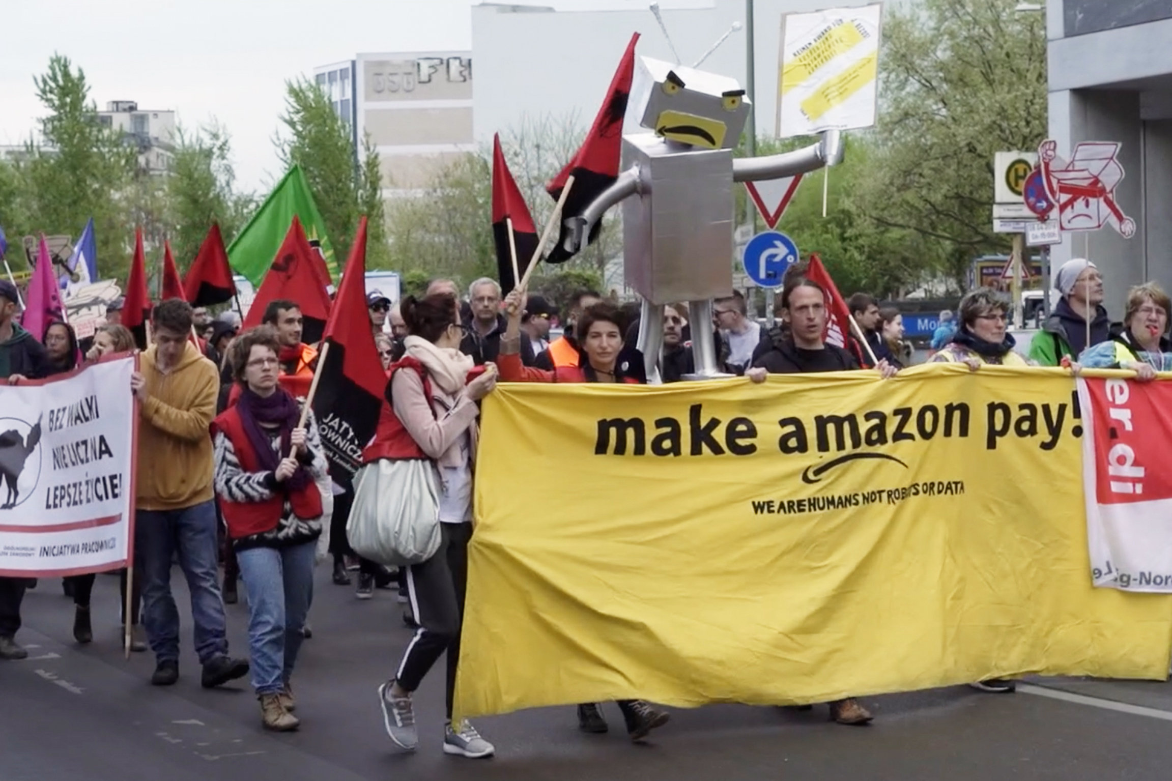 DOK Amazon – Wie der Online-Gigant die Welt beherrscht In Deutschland und an anderen Orten in Europa protestieren Amazon-Mitarbeitende gegen die schlechten Arbeitsbedingungen