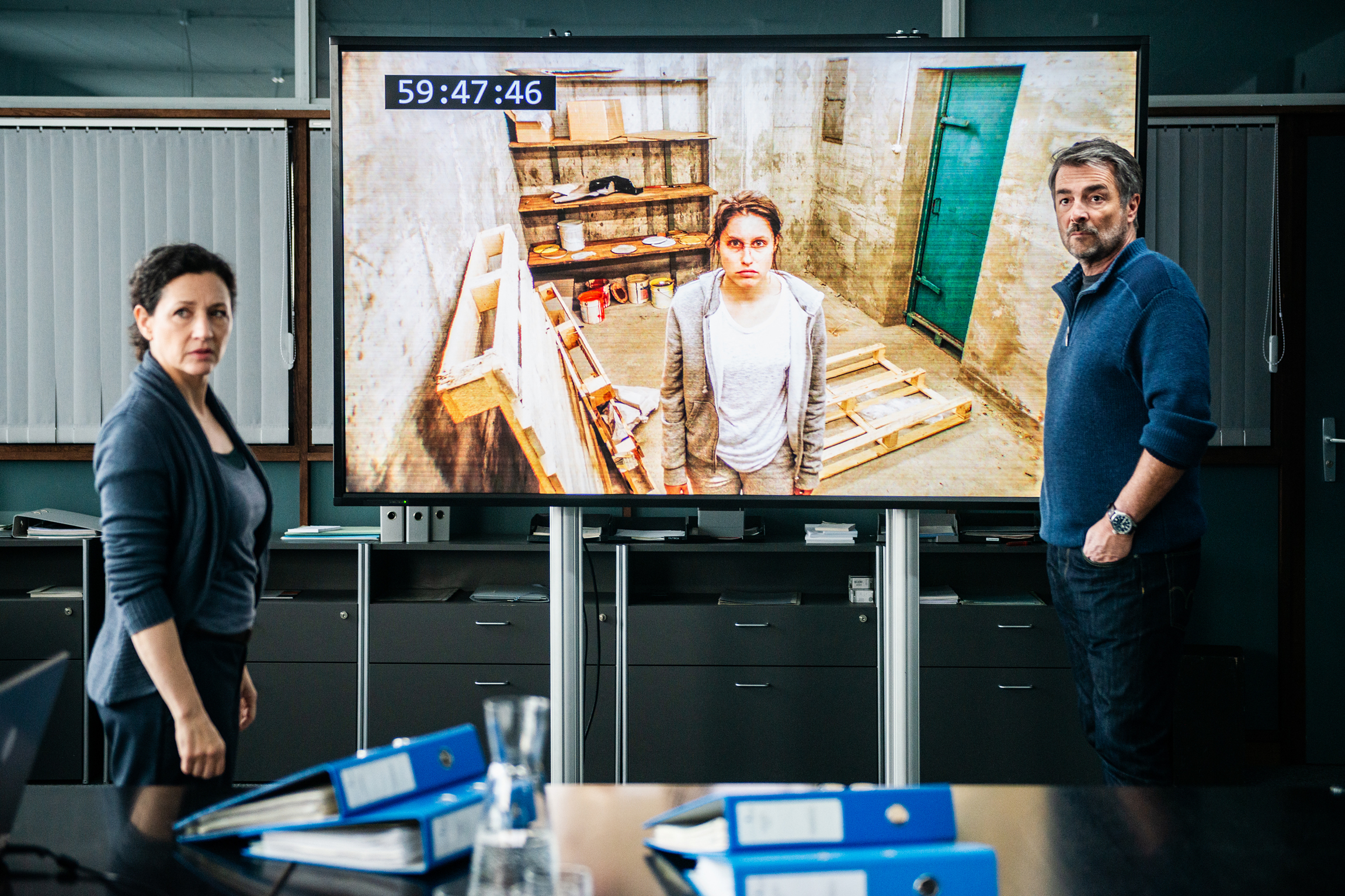 Tatort  Ausgezählt. Livebild vom Entführungsopfer: Delia Mayer als Liz Ritschard und Stefan Gubser als Reto Flückiger im Polizeirevier. Auf dem Monitor sieht man Tabea Buser als die entführte Martina Oberholzer.