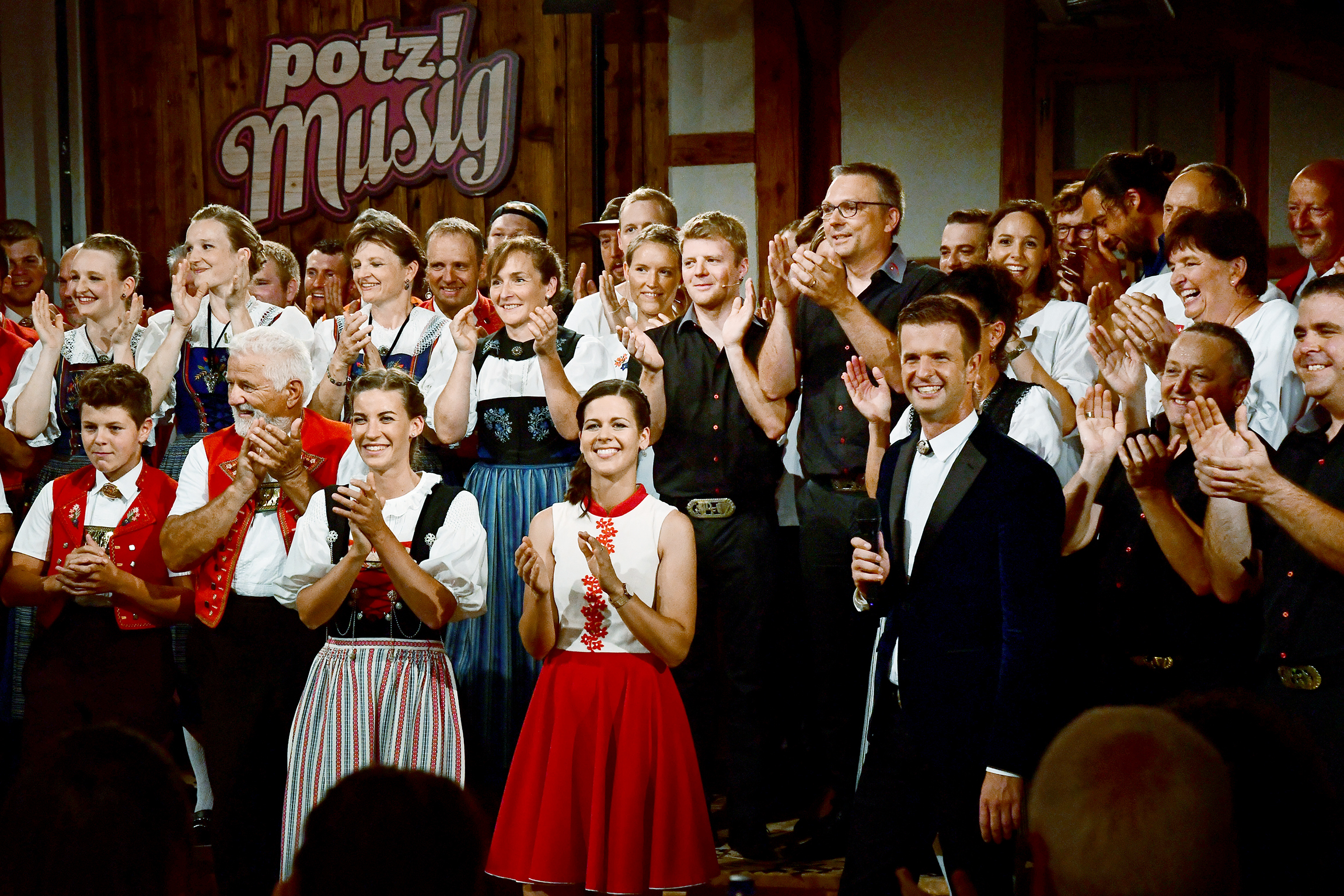 Potzmusig feiert 10-jähriges Jubiläum der Volksmusiksendung am 27.8.2022 Melanie Oesch (vorne M.), Nicolas Senn (vorne 3.v.r.) und Lisa Stoll (vorne 3.v.l.) bei der Aufzeichnung der Jubilaeumssendung 10 Jahre Potzmusig mit Moderator Nicolas Senn am 4. August 2022 im Ribelhof in Luechingen SG.