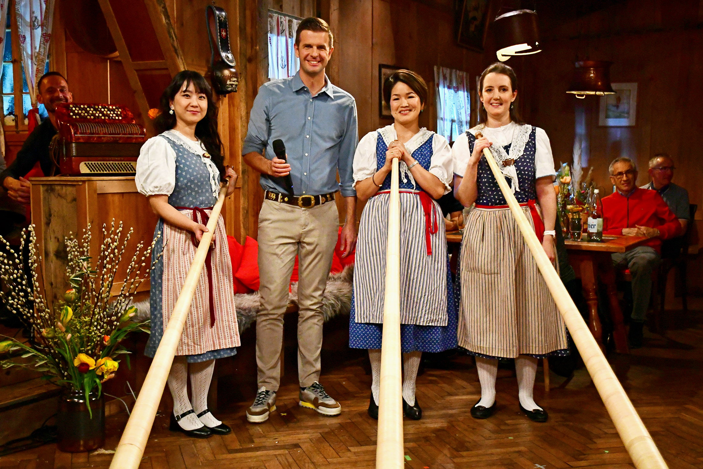 PotzmusigVolkstümliche Klänge aus der Titlis-Hütte LuzernAlpine Sisters V.l.n.r.: Am Alphorn Kumiko Jöhl, Moderator Nicolas Senn, Yui Beck und Annette Cox.Copyright: SRF/eastdesign.ch/Nicolas Senn