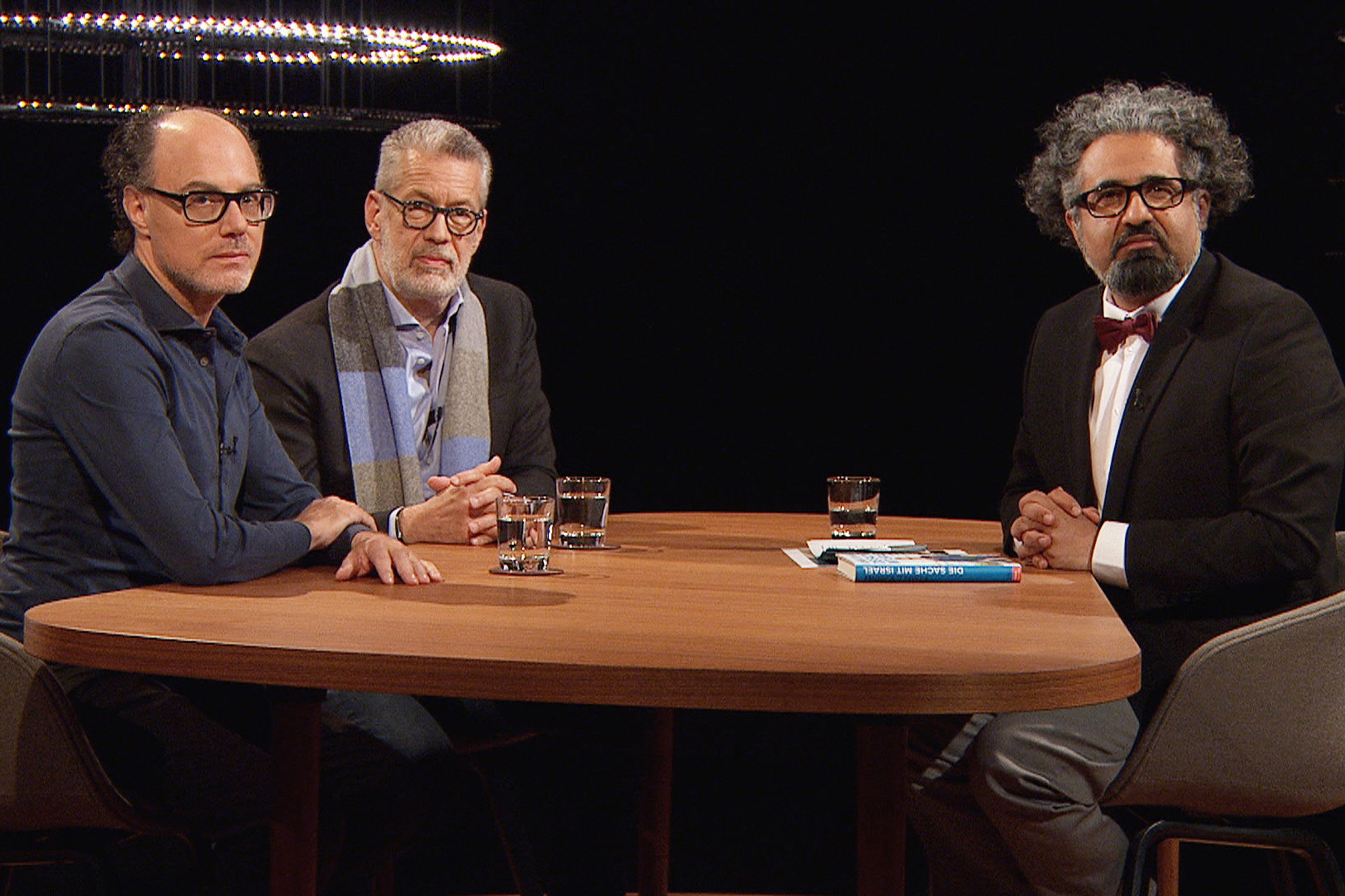 Sternstunde ReligionIsrael wird 75 – Land der Sehnsucht und des religiösen ZwistesJournalist Yves Kugelmann, Richard C. Schneider, Autor und Journalist, mit Moderator Milad KarimiCopyright: SRF