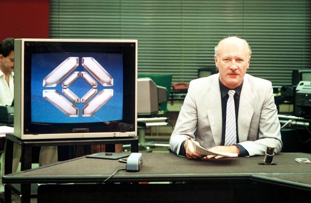 Chronik50 Jahre SF DRSTagesschau mit Sprecher Erich Gysling im Redaktionsbüro und Tagesschau-Studio. Vorne li. Bildschirm mit Logo (Schliessmuskel). Logo von 1985-89.1986Copyright: SF DRS/Alfred Wasescha