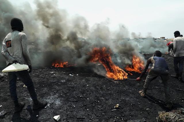 Kauf mich! Junge Männer verbrennen in Accra/Ghana Elektrogeräte, um an verwertbares Metall zu kommen.